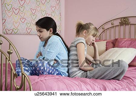 Girl sitting back to back on bed View Large Photo Image Stock Image - Girl sitting back to back on bed. Fotosearch