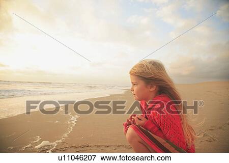 Stock Photo - Girl sitting on beach. Fotosearch