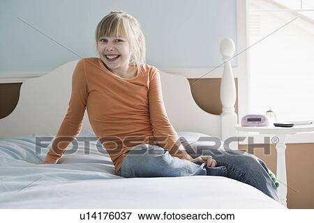 Stock Photo - Girl sitting on bed. Fotosearch