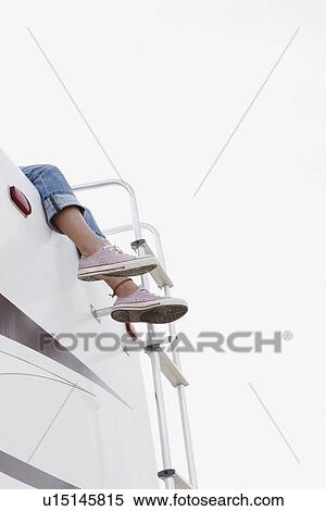 Stock Photography - Girl sitting on top of motor home. Fotosearch