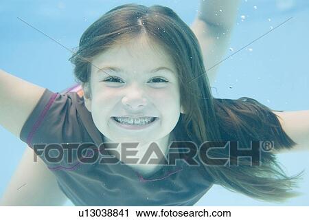 Stock Image - Girl swimming underwater. Fotosearch