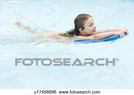 Stock Photograph - Girl using kickboard in swimming pool. Fotosearch