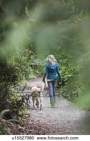 Girl walking dog on forest path View Large Photo Image Stock Image - Girl walking dog on forest path. Fotosearch