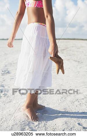 Girl walking with starfish on beach View Large Photo Image Stock Photography - Girl walking with starfish on beach. Fotosearch