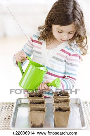 Girl watering small potted plants View Large Photo Image Picture - Girl watering small potted plants. Fotosearch
