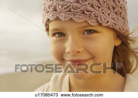 Stock Image - Girl wearing hat at beach. Fotosearch