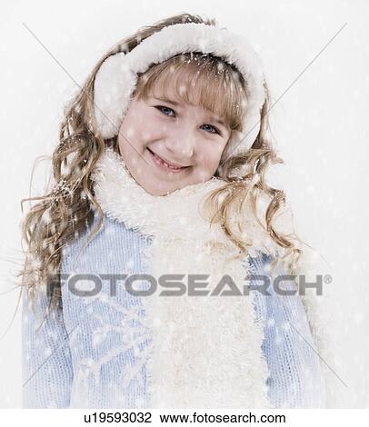 Stock Image - Girl wearing winter clothes in snow. Fotosearch