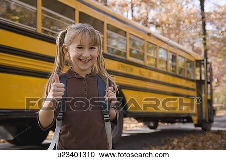 Stock Image - Girl with backpack in front of school bus. Fotosearch