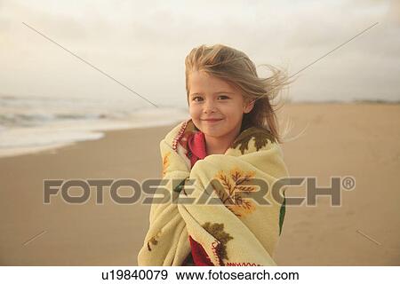 Stock Photo - Girl wrapped in blanket at beach. Fotosearch