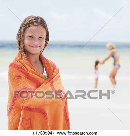 Stock Photo - Girl wrapped in towel on beach. Fotosearch