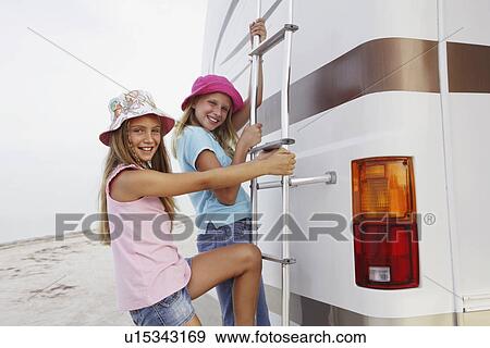 Girls climbing on motor home ladder View Large Photo Image Stock Photo - Girls climbing on motor home ladder. Fotosearch