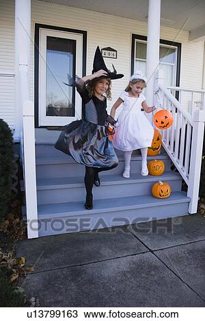 Stock Image - Girls dressed in witch and princess Halloween costumes. Fotosearch