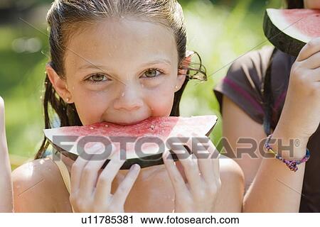 Stock Image - Girls eating watermelon. Fotosearch