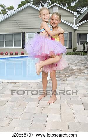 Stock Photo - Girls in tutus playing by swimming pool. Fotosearch