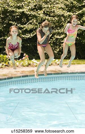 Stock Photo - Girls jumping into swimming pool. Fotosearch