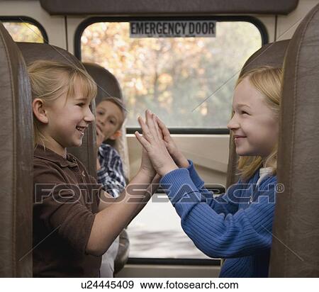 Girls playing paddy cake on school bus View Large Photo Image Stock Photo - Girls playing paddy cake on school bus. Fotosearch