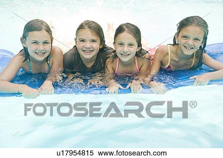 Stock Photography - Girls resting on inflatable raft in swimming pool. Fotosearch