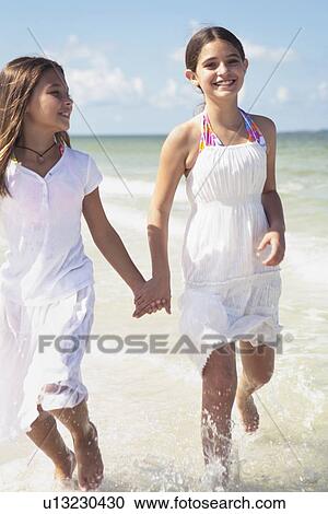 Girls running in ocean View Large Photo Image Stock Image - Girls running in ocean. Fotosearch