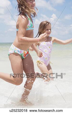 Girls running in ocean View Large Photo Image Stock Photo - Girls running in ocean. Fotosearch