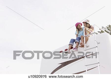 Girls sitting on top of motor home View Large Photo Image Stock Photograph - Girls sitting on top of motor home. Fotosearch