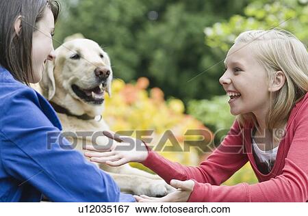 Girls sitting with dog in park View Large Photo Image Stock Photo - Girls sitting with dog in park. Fotosearch