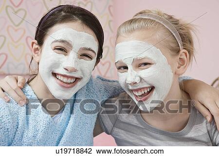 Stock Image - Girls with facial treatment laughing. Fotosearch