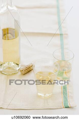 Glasses of white wine and wine bottle View Large Photo Image Stock Image - Glasses of white wine and wine bottle. Fotosearch