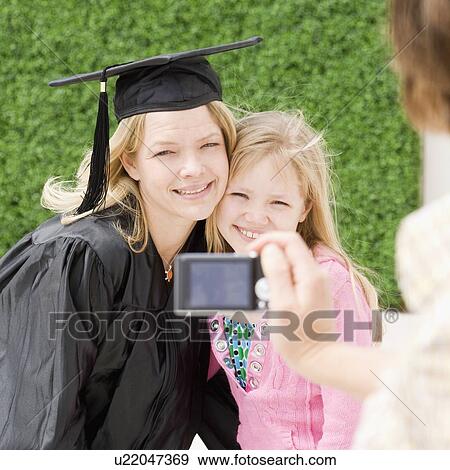 Stock Photo - Graduate mother and daughter having photograph taken. Fotosearch