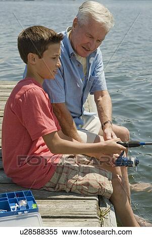 Stock Photography - Grandfather and grandson fishing off dock. Fotosearch