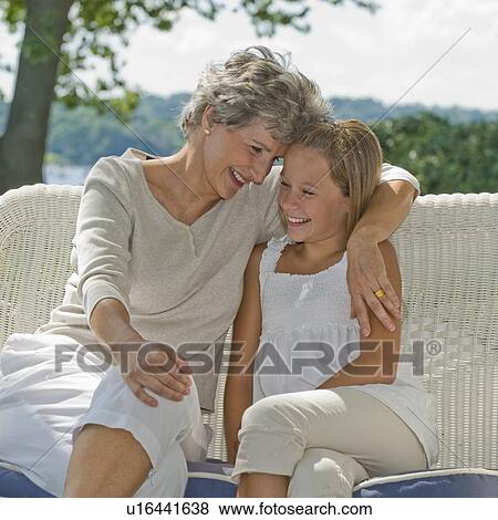 Stock Photo - Grandmother and granddaughter sitting on porch. Fotosearch