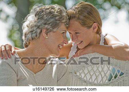 Stock Photograph - Grandmother and granddaughter smiling at each other. Fotosearch