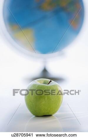 Green apple with globe in background View Large Photo Image Stock Image - Green apple with globe in background. Fotosearch