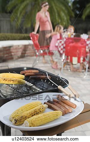 Grilled hotdogs and corn on backyard grill View Large Photo Image Picture - Grilled hotdogs and corn on backyard grill. Fotosearch