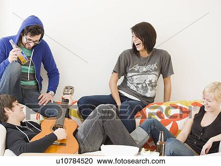 Group of friends relaxing on sofa View Large Photo Image Stock Image - Group of friends relaxing on sofa. Fotosearch