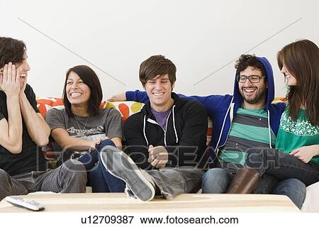 Group of friends sitting on sofa View Large Photo Image Stock Photo - Group of friends sitting on sofa. Fotosearch