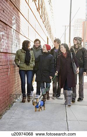 Stock Photo - Group of friends walking on urban sidewalk. Fotosearch