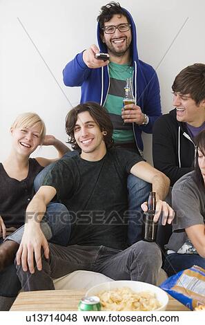Group of friends watching television View Large Photo Image Stock Photo - Group of friends watching television. Fotosearch