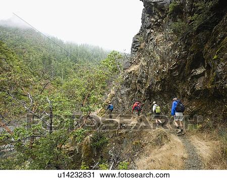 Stock Image - Group of hikers hiking on trail. Fotosearch
