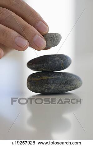 Hand stacking stones View Large Photo Image Stock Photo - Hand stacking stones. Fotosearch