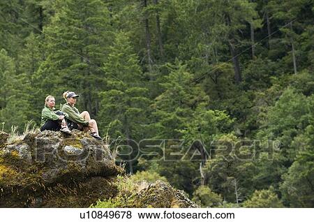 Stock Photo - Hikers enjoying view from rock outcropping. Fotosearch