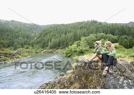Stock Photography - Hikers enjoying view of river. Fotosearch