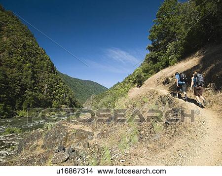 Hikers walking on riverside trail View Large Photo Image Picture - Hikers walking on riverside trail. Fotosearch