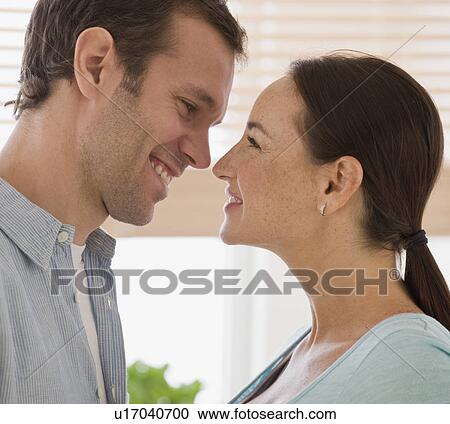 Stock Image - Hispanic couple smiling at each other. Fotosearch