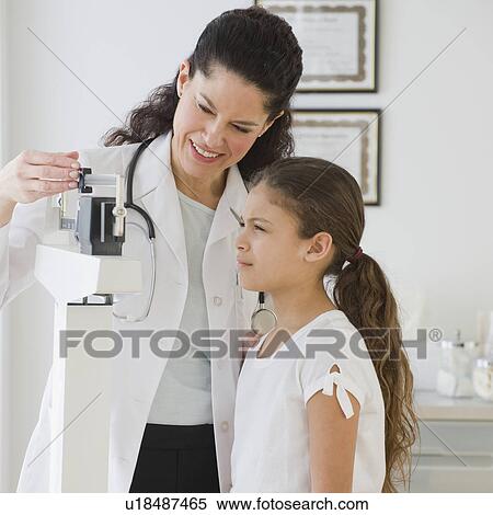 Stock Photography - Hispanic female doctor weighing child. Fotosearch