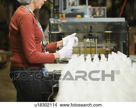 Hispanic female factory worker checking product View Large Photo Image Picture - Hispanic female factory worker checking product. Fotosearch