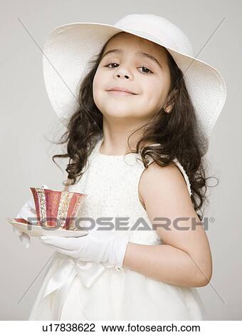 Stock Image - Hispanic girl dressed up at tea party. Fotosearch