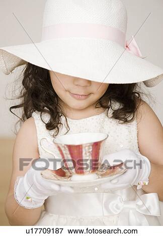 Stock Photo - Hispanic girl dressed up at tea party. Fotosearch
