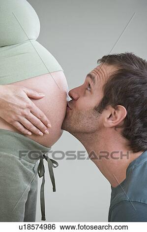 Hispanic man kissing pregnant wife’s belly View Large Photo Image Stock Photograph - Hispanic man kissing pregnant wife’s belly. Fotosearch