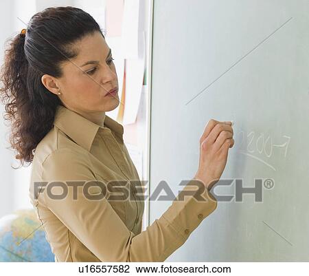 Hispanic teacher writing on blackboard View Large Photo Image Stock Image - Hispanic teacher writing on blackboard. Fotosearch