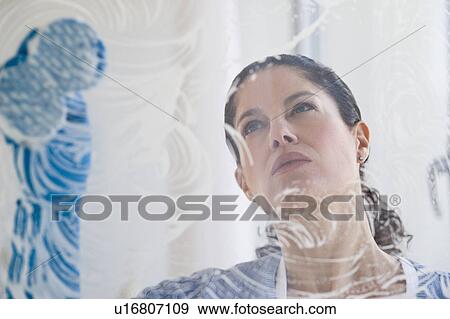 Stock Photo - Hispanic woman washing window. Fotosearch